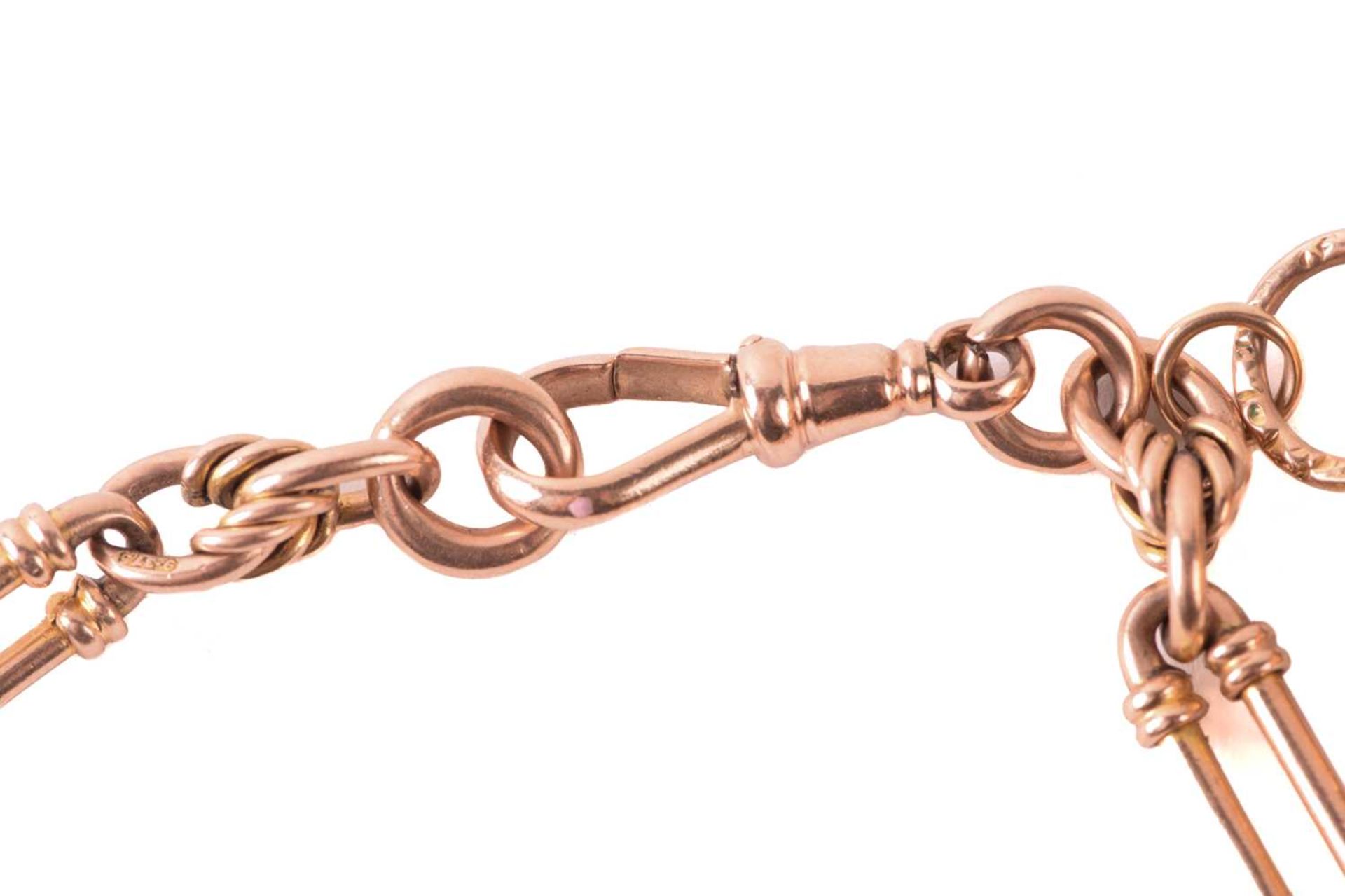 A 9ct rose gold watch chain with charms, comprising a trombone link chain terminated with a swivel - Image 4 of 4