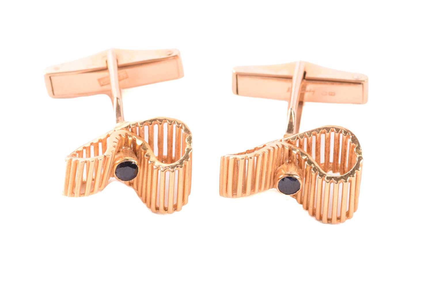 Kutchinsky - a pair of 18ct yellow gold cufflinks set with sapphires, of undulating ribbon design,