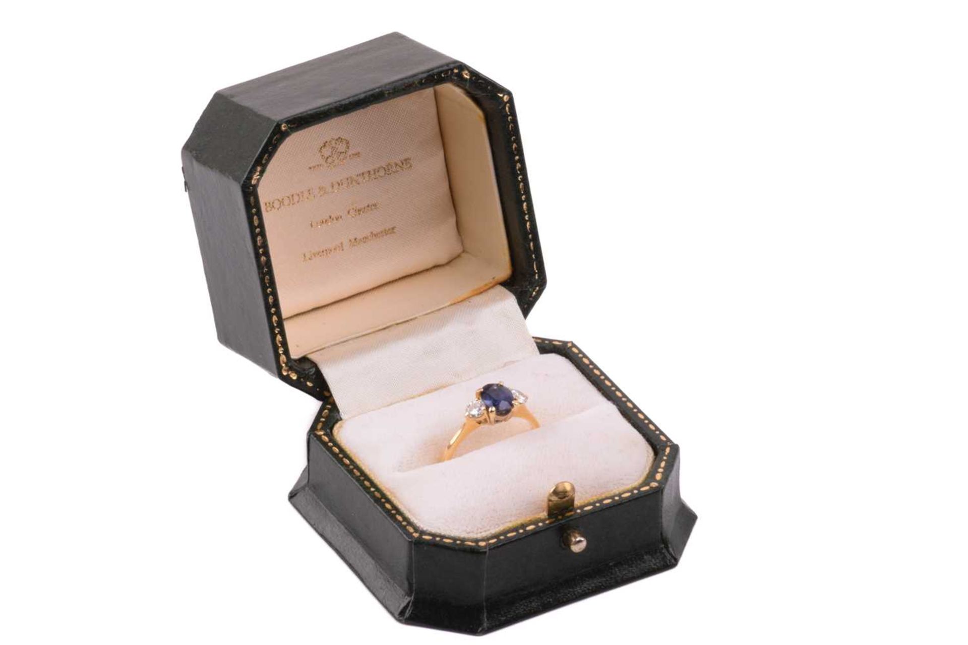 A Boodle & Dunthorne sapphire and diamond three stone ring, set with a central oval sapphire - Image 2 of 6