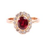 A synthetic ruby and diamond cluster ring, centred with an oval-cut synthetic ruby in collet,