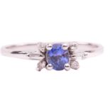A sapphire and diamond dress ring, centred with an oval-cut sapphire of purplish-blue, with