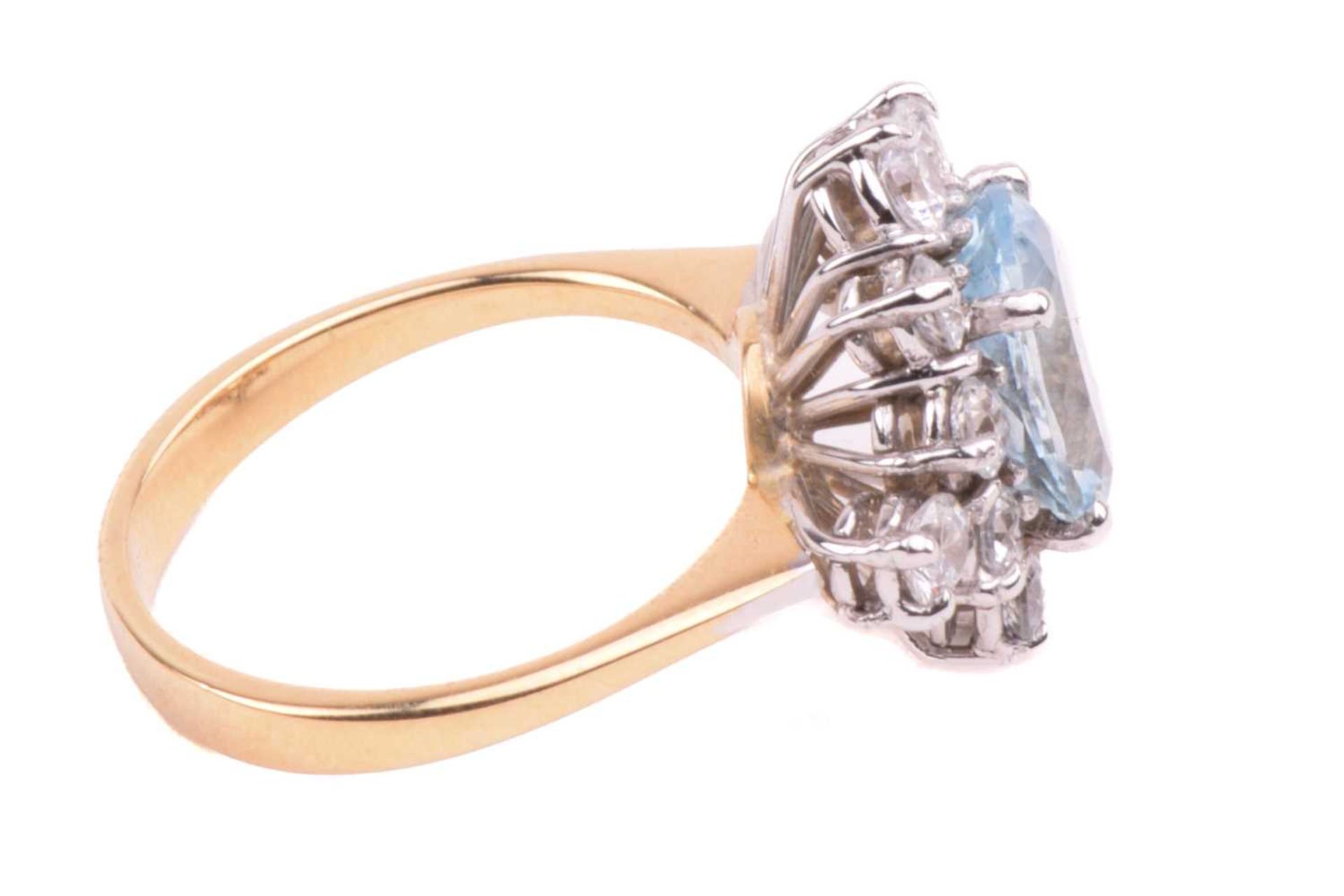 An aquamarine and CZ cluster ring in 18ct gold, comprising an oval-cut aquamarine of light blue - Image 3 of 5