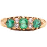 An emerald and diamond half hoop ring, set with three emeralds, the largest measuring 4mm x 3.2mm,