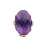 A large amethyst cocktail ring, set with an oval fancy cut amethyst of 25mm x 18mm x 14mm, each