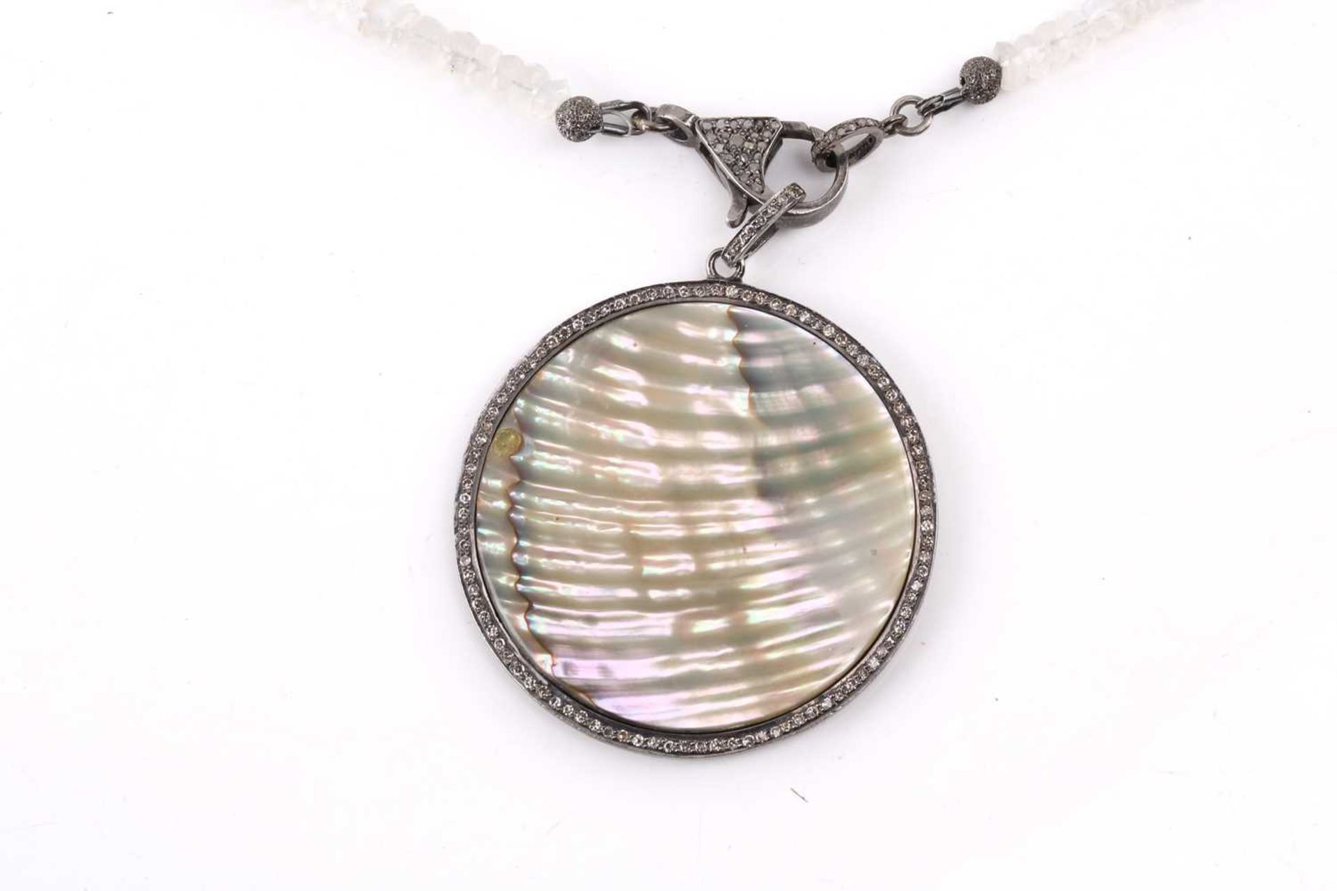 A diamond and mother of pearl pendant, the central polished circle of mother of pearl surrounded - Image 2 of 4