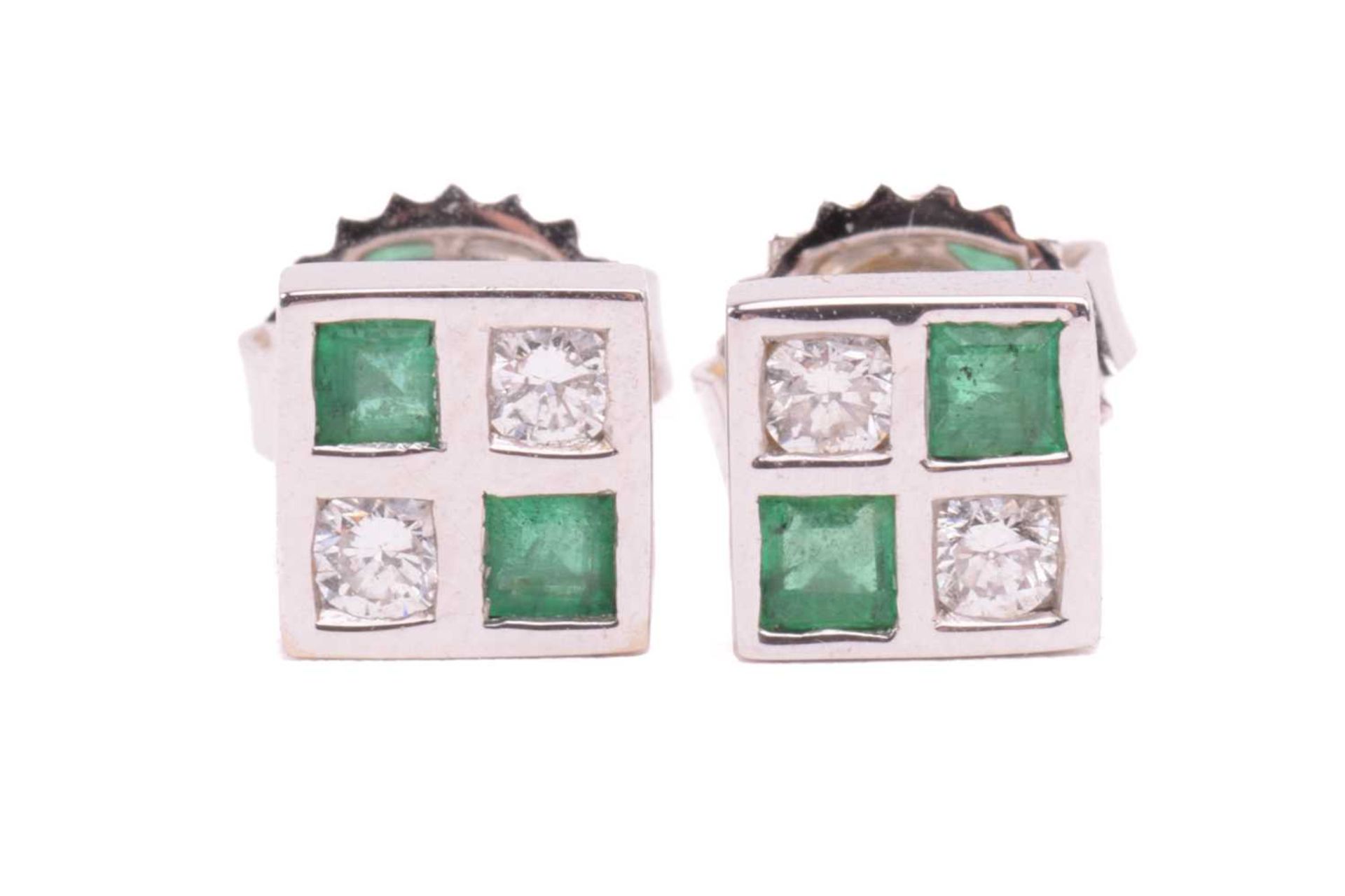 A pair of emerald and diamond stud earrings in 18ct white gold, each comprising two circular-cut