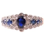 A sapphire and diamond dress ring in 9ct gold, claw-set with an oval-cut sapphire of 6.1 x 4.3 mm