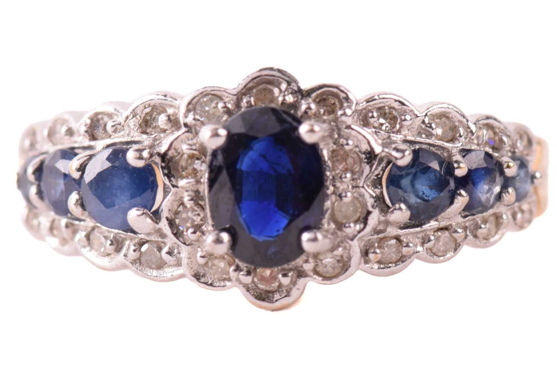 A sapphire and diamond dress ring in 9ct gold, claw-set with an oval-cut sapphire of 6.1 x 4.3 mm