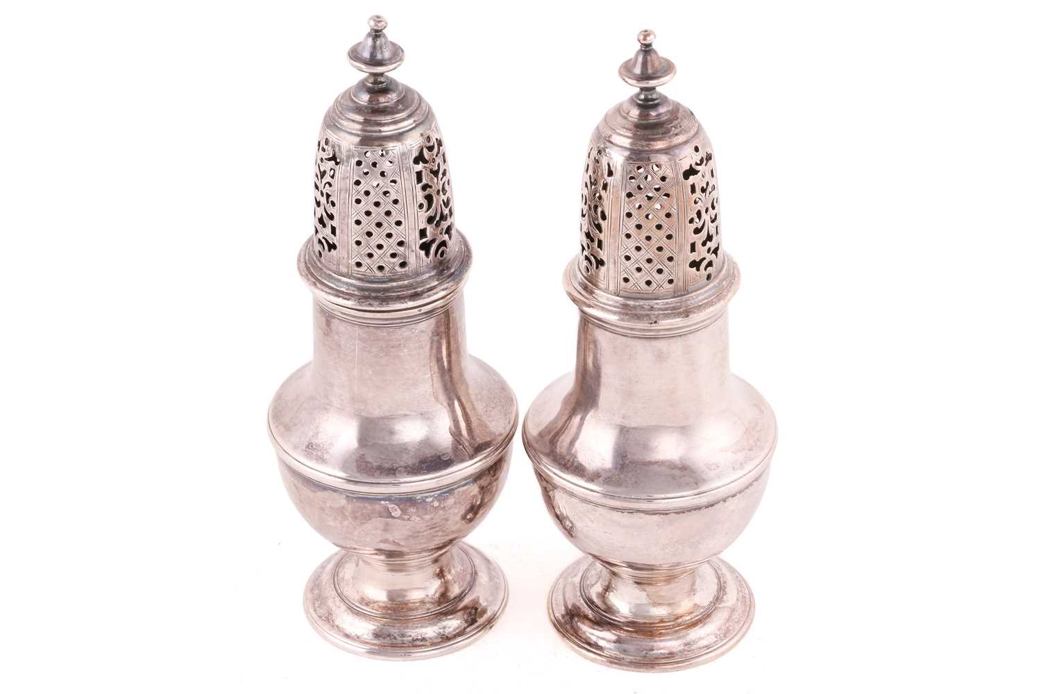 A pair of George III silver sugar casters, London 1779 by Samuel Wood, each of baluster form on