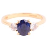 A Boodle & Dunthorne sapphire and diamond three stone ring, set with a central oval sapphire