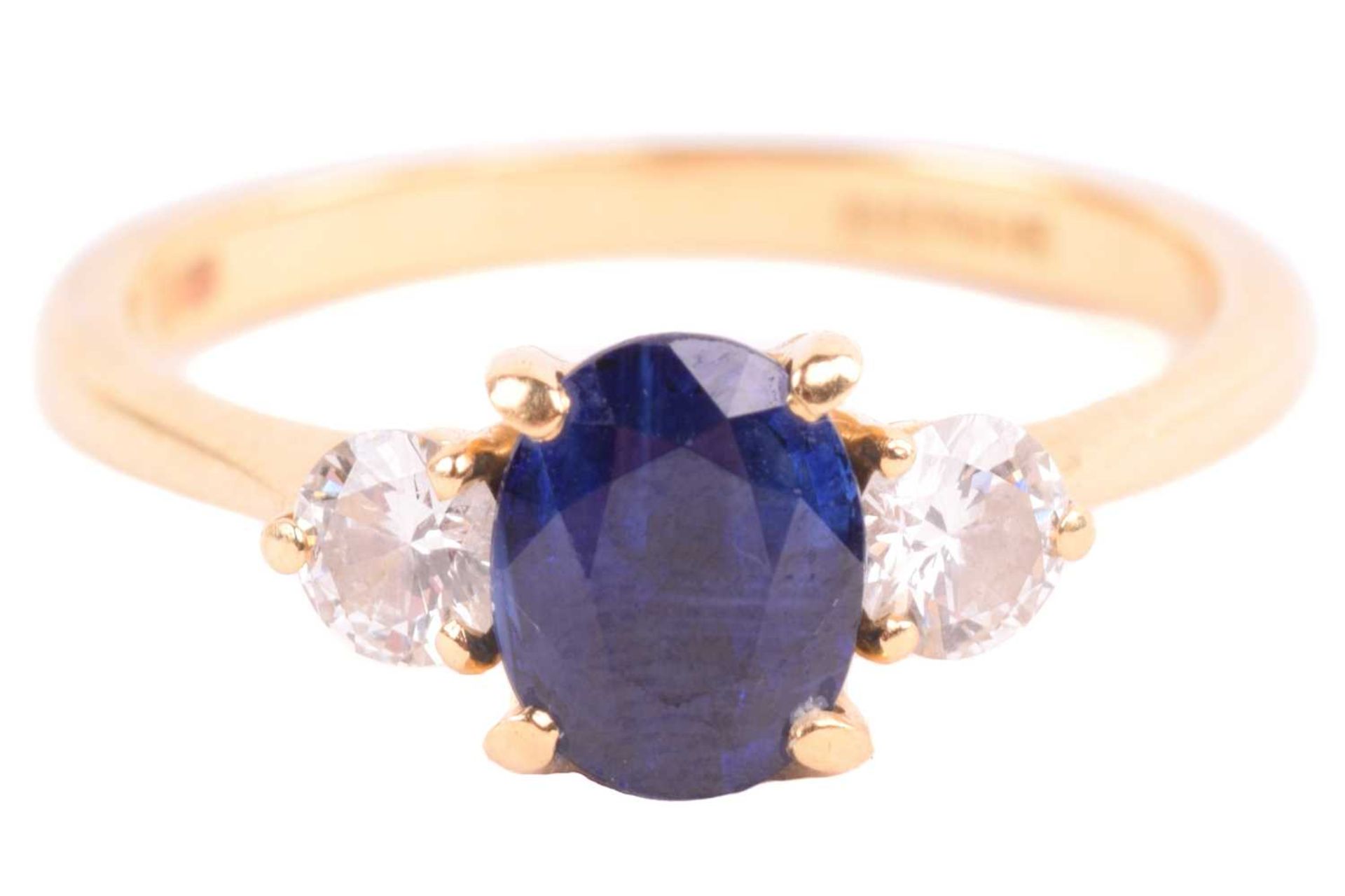 A Boodle & Dunthorne sapphire and diamond three stone ring, set with a central oval sapphire