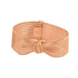 A pinched woven mesh bracelet, with an openwork motif of scrolled patterns and florentine finish,