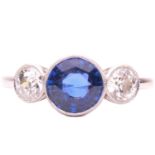 A sapphire and diamond trilogy ring, featuring a circular-cut Ceylon sapphire of 2.04ct, with bright