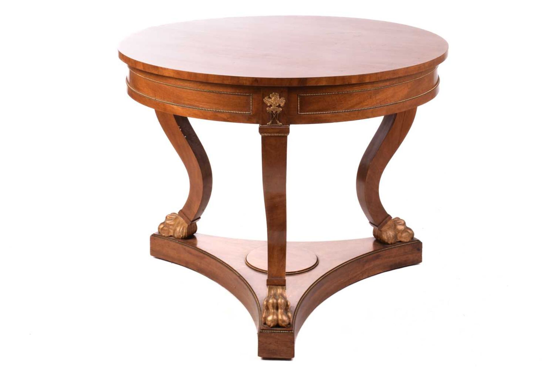 A French Empire Style centre table, the circular top over a gilt beaded panelled frieze and