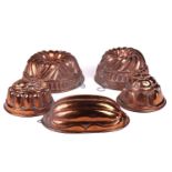 A collection of five probably French 20th-century copper jelly moulds including two circular pipe