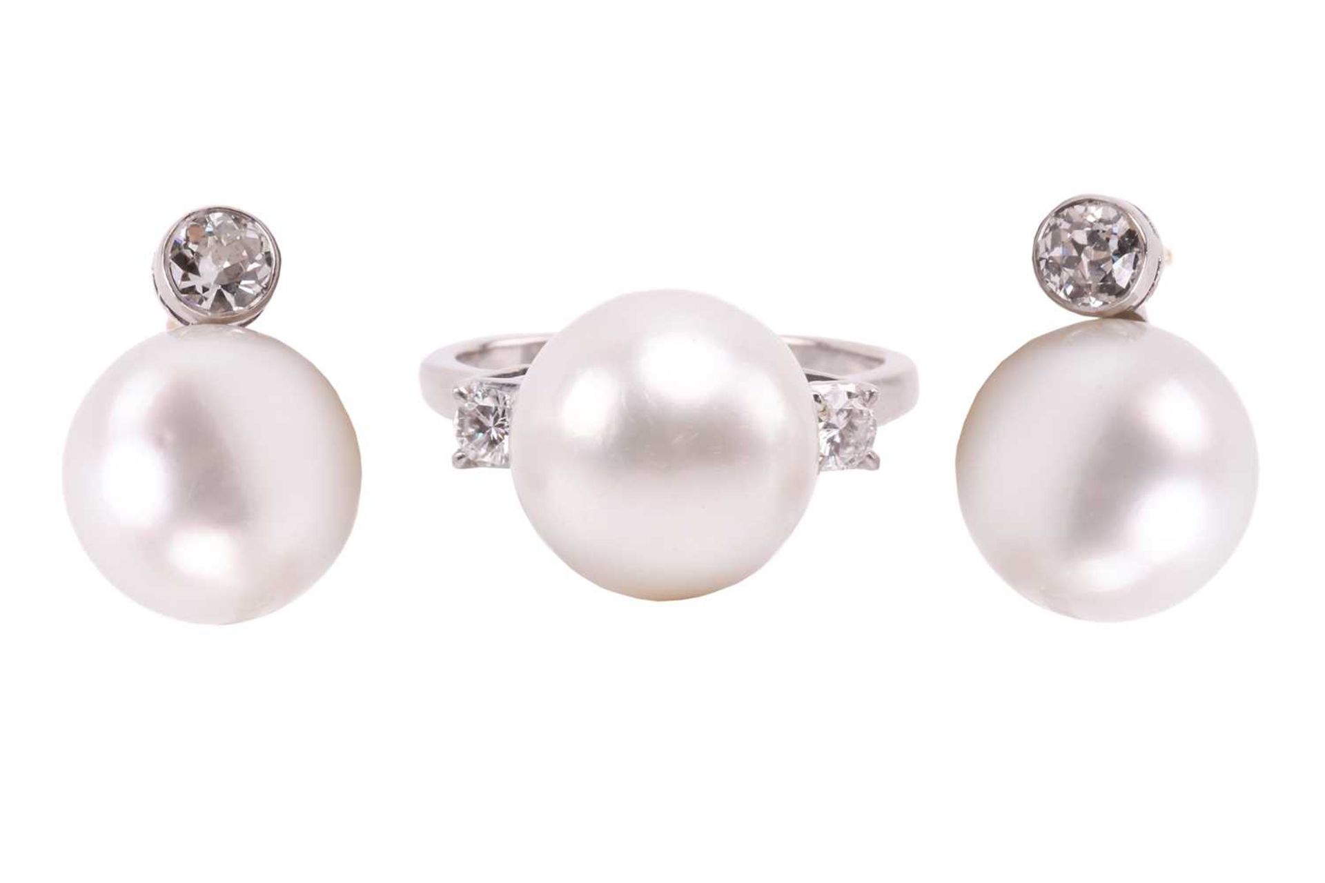 A pair of pearl and diamond earrings and a ring en suite; the central single freshwater pearl