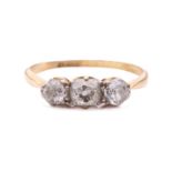 A diamond three stone ring, set with a central cushion shape old cut diamond between round old cut