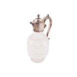 A Victorian silver mounted claret jug; the domed cover with ball finial; leaf- capped scroll