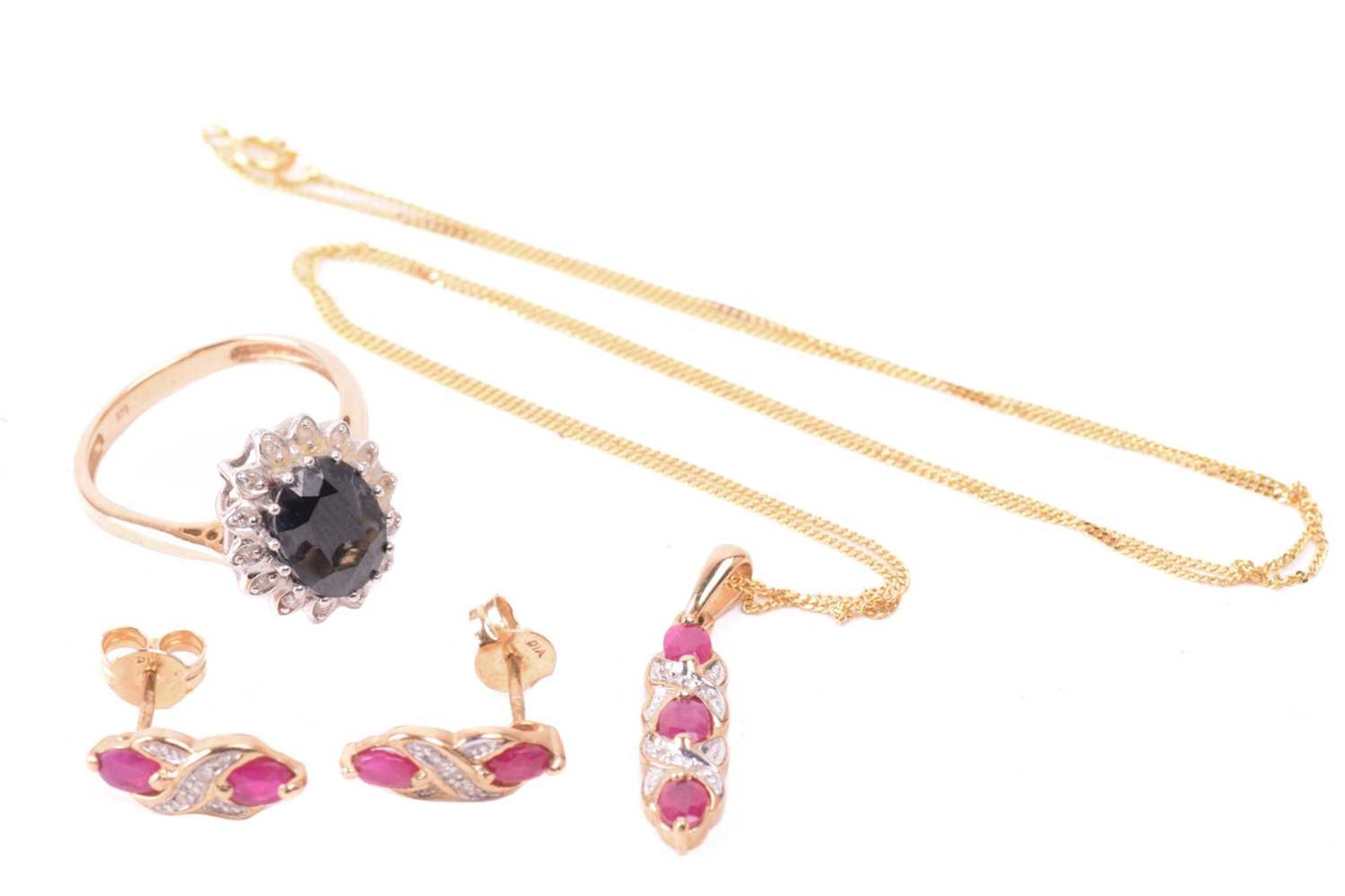 A ruby necklace and earrings ensuite together with a dress ring; the pendant set with three oval-cut