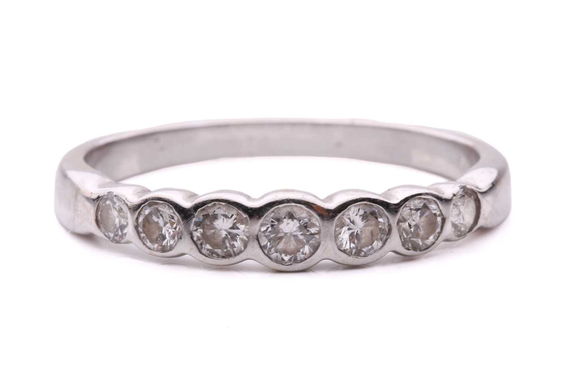 A diamond seven stone half hoop eternity ring, featuring a row of round brilliant cut diamonds