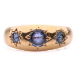 An Edwardian three-stone sapphire gypsy ring in 18ct gold, star-set with three graduated circular-