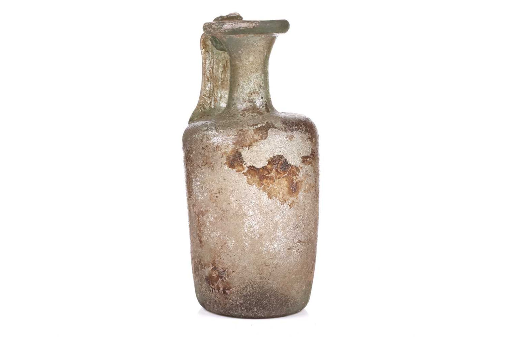 A Roman glass oil ewer of slightly perpendicular form with moulded strap handle to the everted