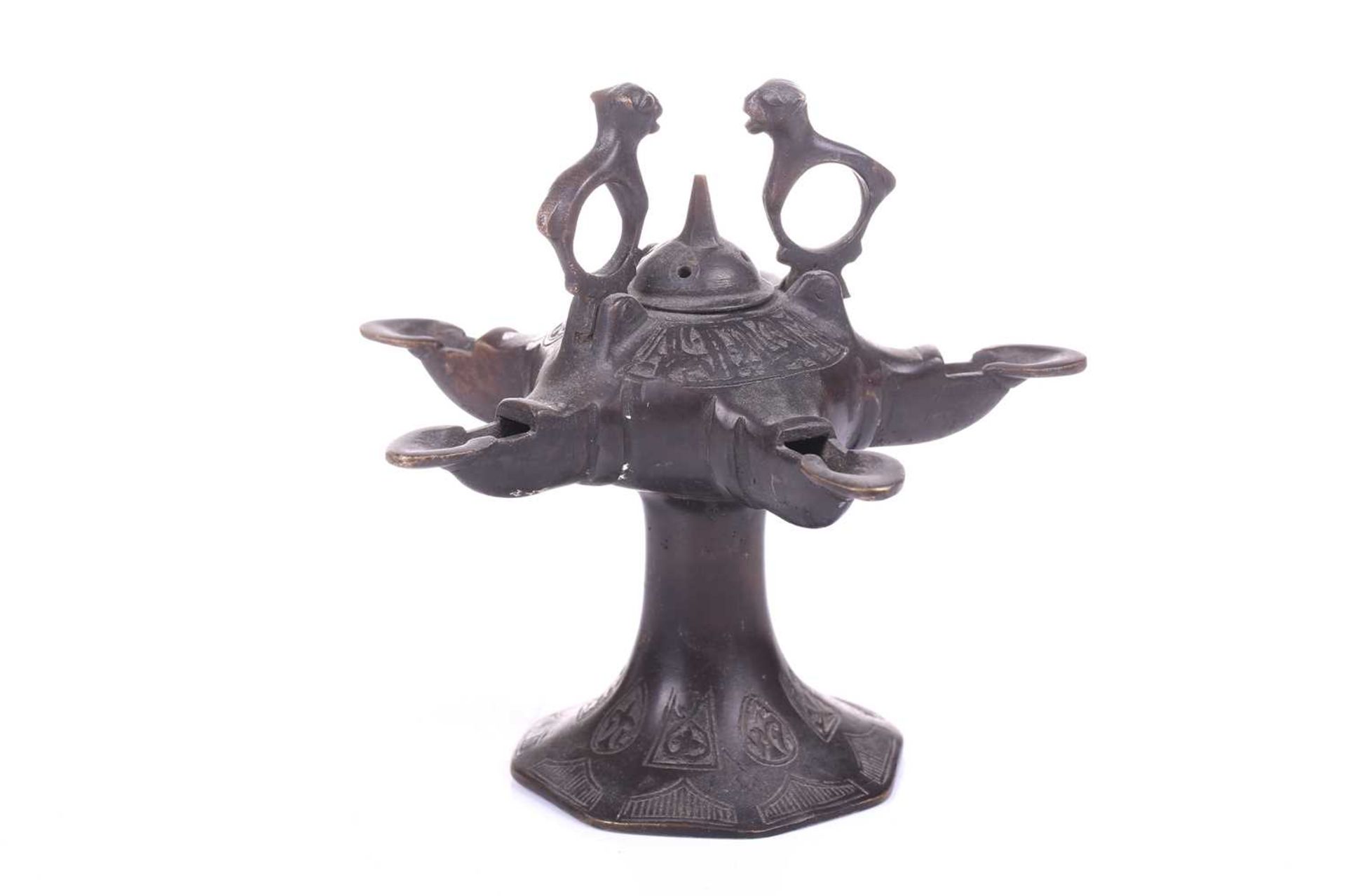 A Bactrian-style oil lamp, with five spouts around a central hinged lid and two mythical beast