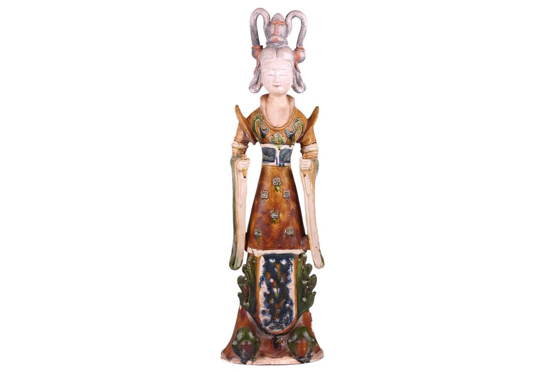 A Chinese sancai glazed pottery standing court figure, Minqi, (spirit object) possibly Tang dynasty,