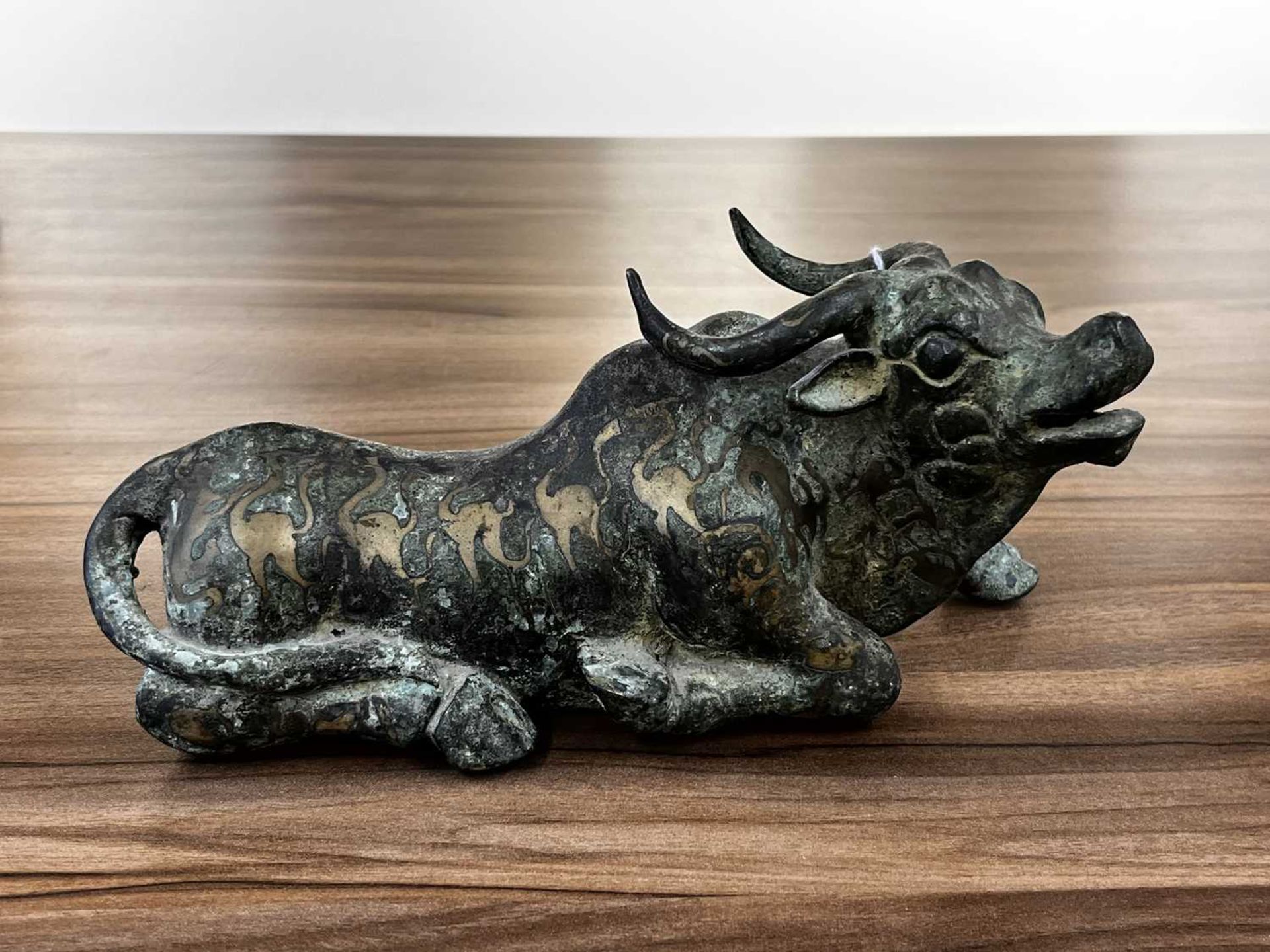 A Chinese bronze and gilt recumbent bull, possibly Zhou dynasty or later, the animal with one leg - Image 10 of 20