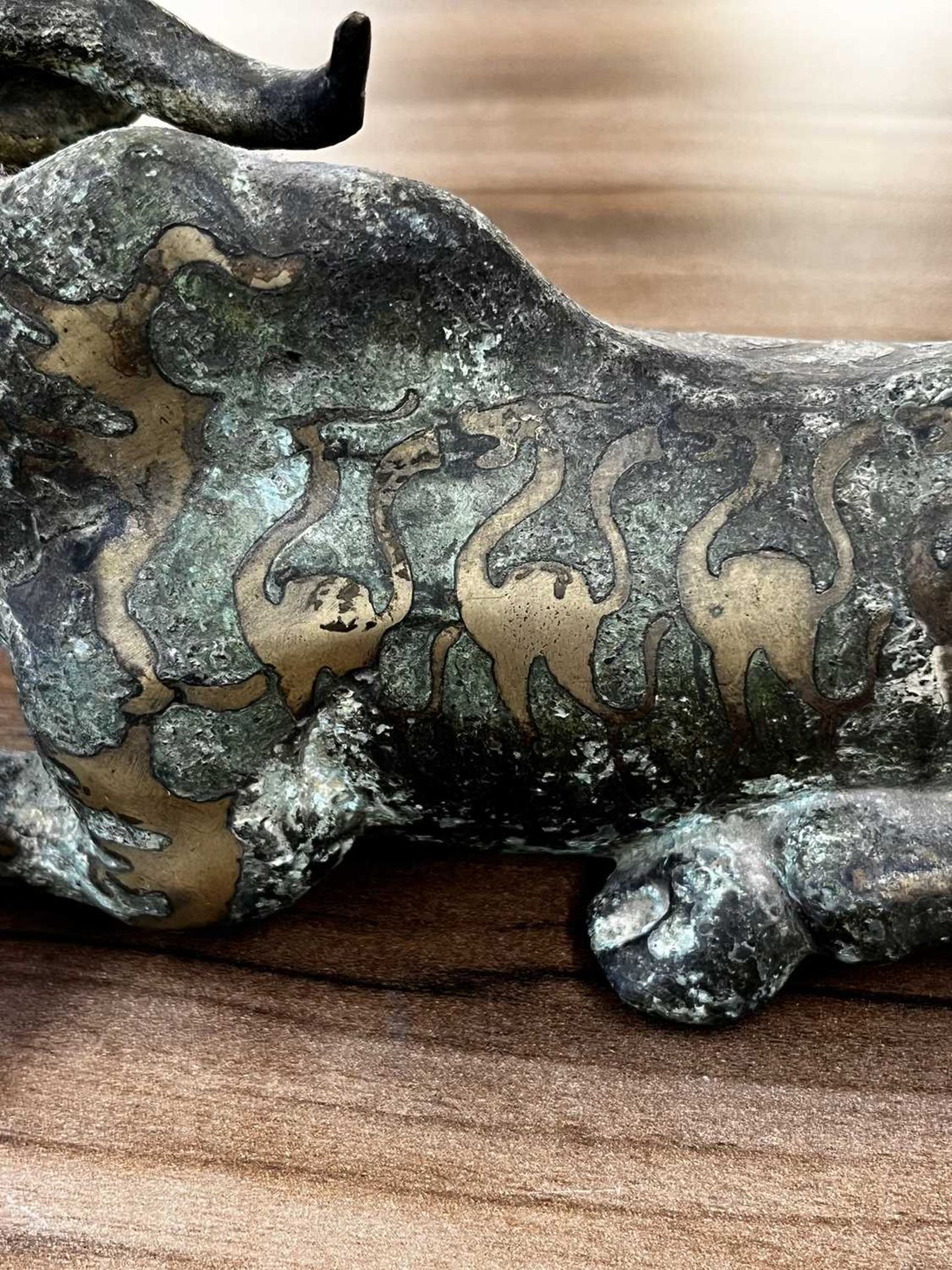 A Chinese bronze and gilt recumbent bull, possibly Zhou dynasty or later, the animal with one leg - Image 14 of 20