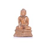 A carved figure of Maravijaya buddha, probably Burmese, 19th century, seated on a pedestal in a