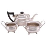 A silver three-piece tea set, of oval form with beaded rims, each piece on four claw feet, the