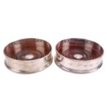 A pair of boxed good quality modern heavy silver bottle coasters with turned hardwood inserts and