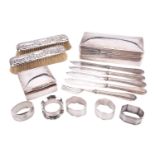 A small collection of silver items including napkin rings, brushes, cigar and cigarette boxes and