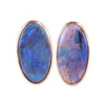 A pair of black opal stud earrings in 18ct yellow gold, one of the oval cabochons is a boulder
