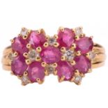A ruby and diamond cluster ring, set with oval rubies and round brilliant cut diamonds, the shank