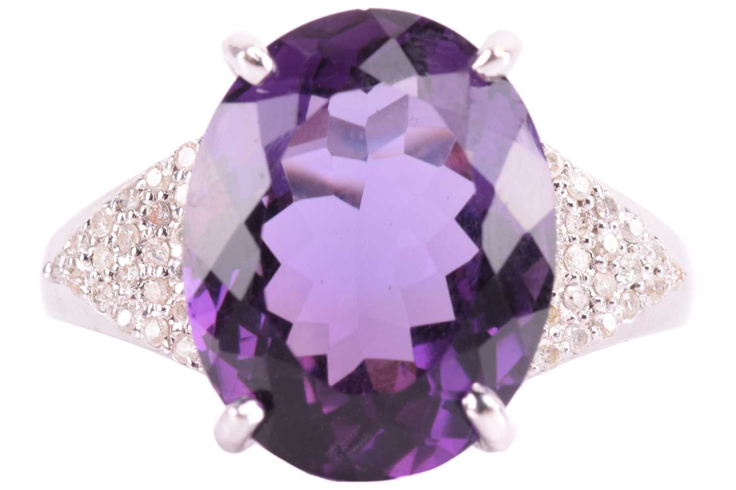 A large amethyst and diamond cocktail ring, featuring an oval-cut amethyst in deep purple colour,