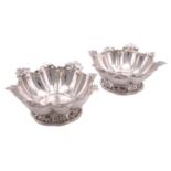 A pair of Edwardian bon bon dishes; shaped circular with lobed bowls and pierced rims, on foliate