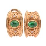 A pair of emerald and diamond earrings, each set with a central cabochon emerald between round