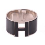 Hermès - an extra wide 'Clic Clac H' bracelet with black enamel and white-toned metal, signed and