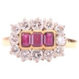 A Ruby and diamond set cluster ring, featuring three central rub set emerald cut rubies surrounded