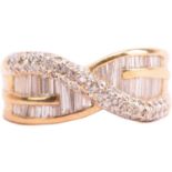 A diamond crossover ring, set with baguette-cut diamonds and rows of round brilliant cut diamonds,