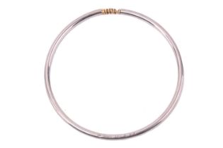 A closed bangle with articulated panel of rings, stamped AM STAINLESS LAMM 609A, internal