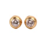 A pair of diamond stud earrings, each set with a round brilliant cut diamond in a rub-over