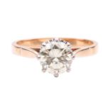 A diamond solitaire ring set with a light yellow round brilliant cut diamond with an estimated