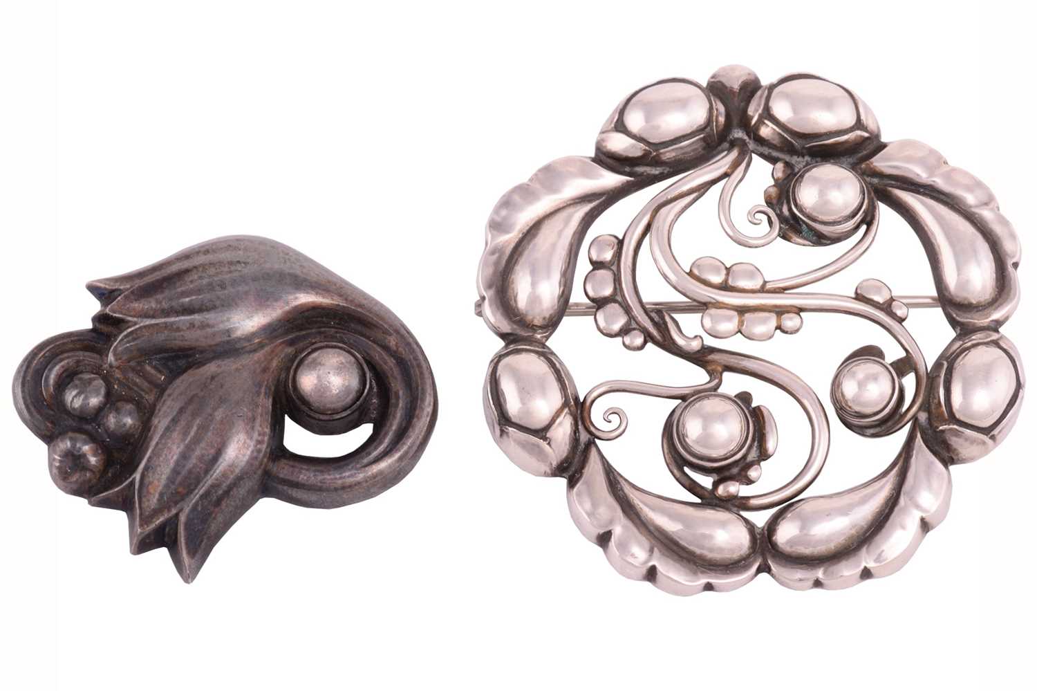 Georg Jensen - a tulip brooch and an openwork foliate brooch; the tulip brooch collet-set with a