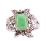 A jade and diamond ring, set with a central sugarloaf cabochon jade measuring 9.4 x 7.5mm, within