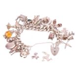 A silver charm bracelet, the silver curb chain with hallmarked heart padlock clasp, with a large