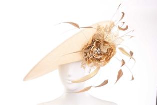 A Philip Treacy sinamay hat in beige, adorned with golden floral decorations on the side. Cased in
