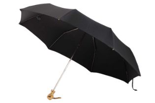 Alexander McQueen - a black folding umbrella with gold-tone skull handle, snap opening with chain